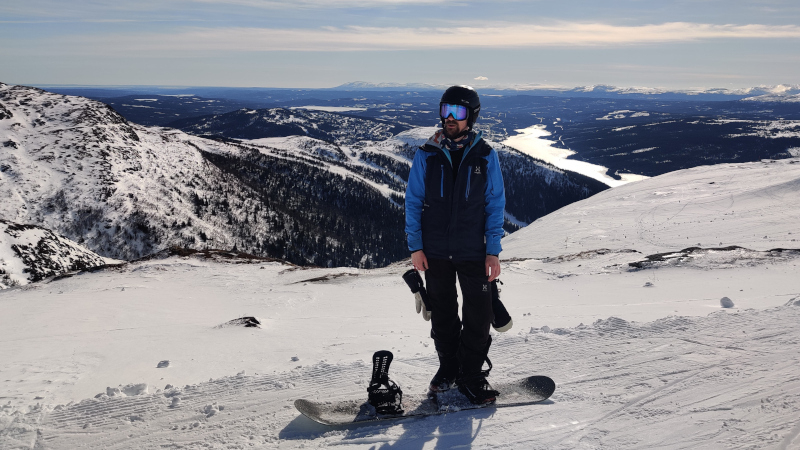 Me standing on a snowboard in the mountains of Åre.