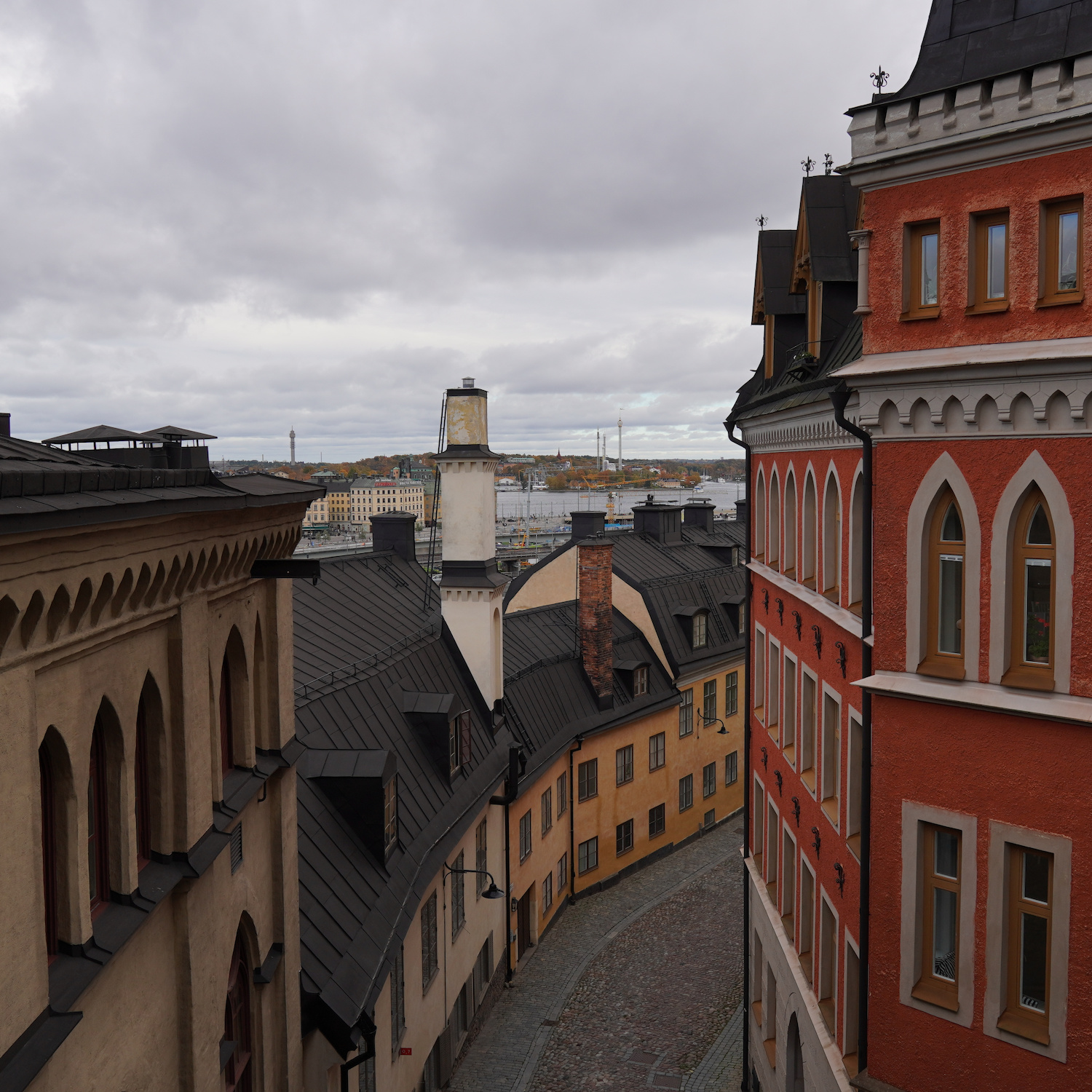 An alley viewed from a bridge where you can see a theme park in the far distance.
