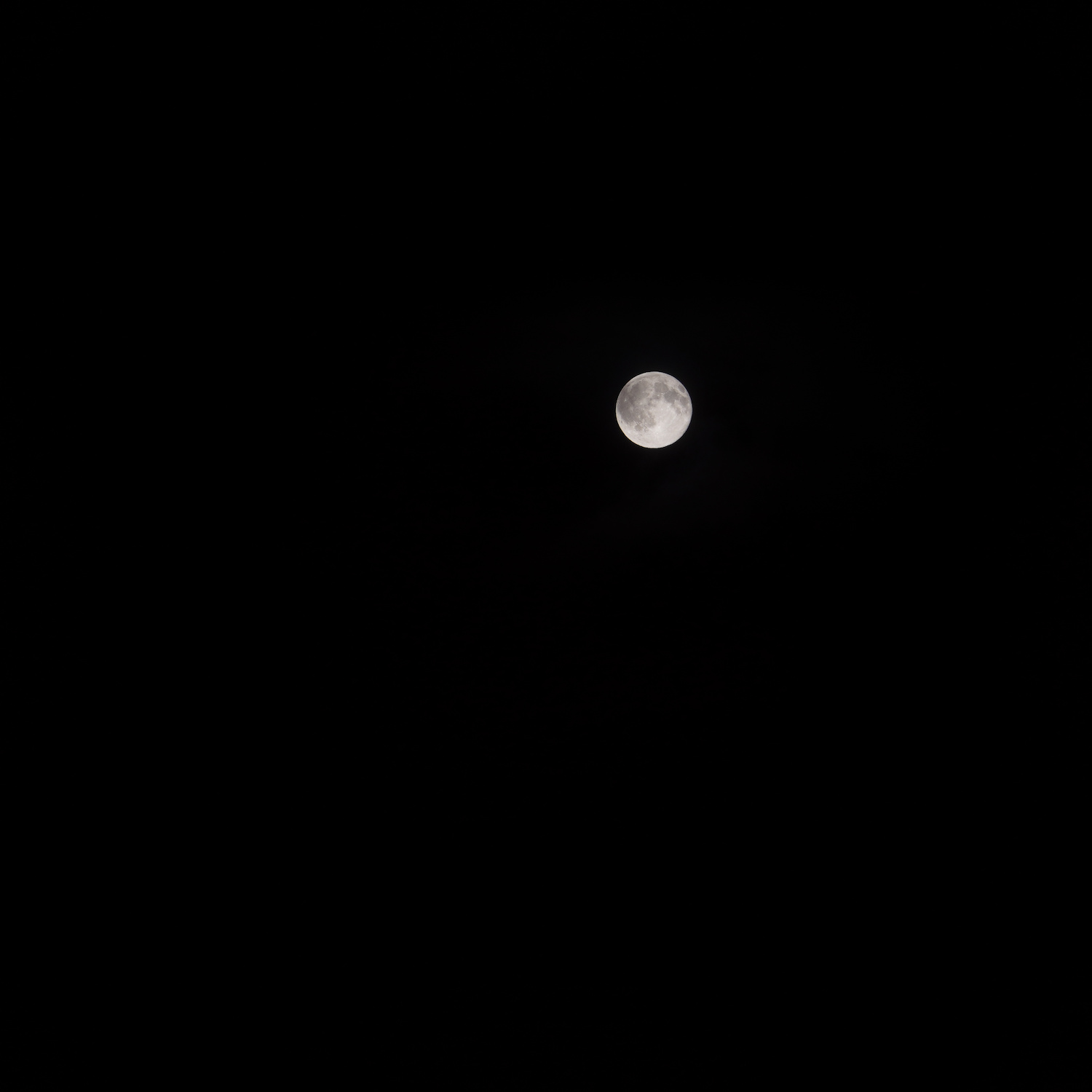The moon with a black background and some clouds.